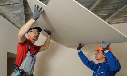Drywall,Installers.,Men,Holding,A,Gypsum,Board,Figured,Cut